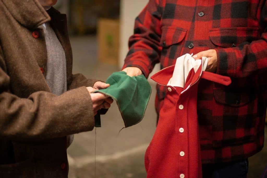 handing green fabric to another person